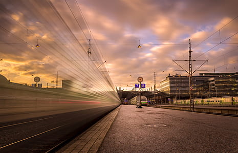 timelapse photography of train near utility post thumbnail