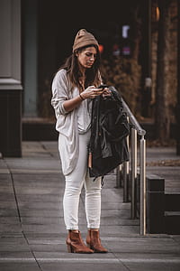 woman standing while using phone thumbnail