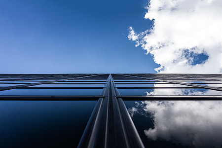 worm's eye view of glass buildings under cloudy blue sky thumbnail