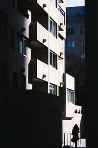 silhouette of woman walking at the alley between buildings thumbnail