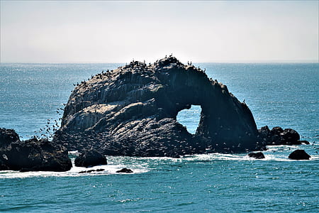 rock formation on body of water during daytime thumbnail