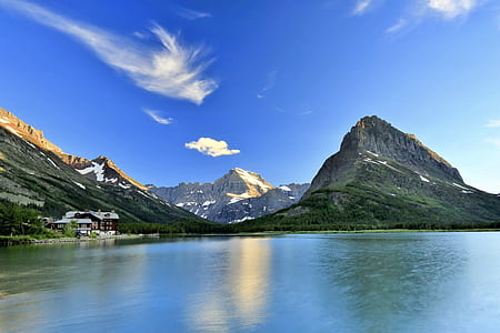 landscape photo of body of water beside high mountains under blue sky at daytime thumbnail