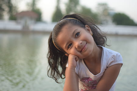 girl sitting near body of water thumbnail