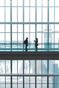 man and woman talking inside glass building thumbnail