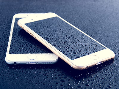 two turned-off iPhones on black surface thumbnail