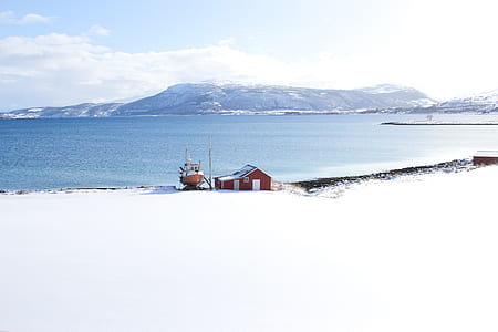 photo of red house and boat near body of water thumbnail