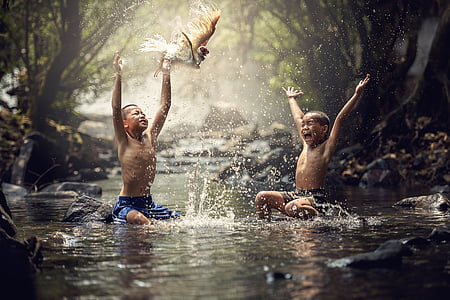 two topless boys taking a bath on streams at daytime thumbnail