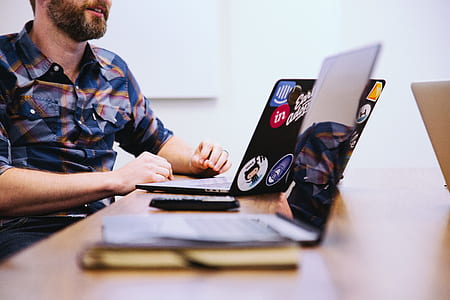 man sitting on chair near table facing laptop computer thumbnail