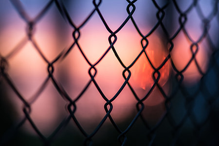 Closeup shot of a metal mesh fence at sunset thumbnail