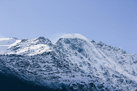 mountain coated with snow under blue sky thumbnail