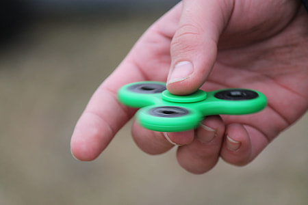 person holding tri-spin fidget toy thumbnail