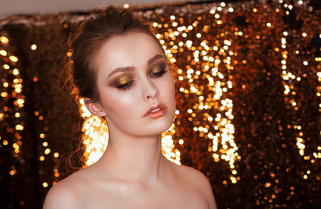 woman with brown eyeshadow near string lights thumbnail