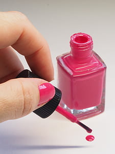 person holding pink nail polish brush thumbnail