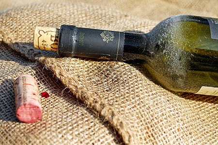 green labeled bottle on brown textile thumbnail