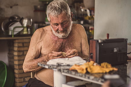 man sitting on chair while eating thumbnail