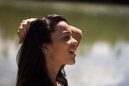 selective focus photography of woman smiling holding her hair thumbnail