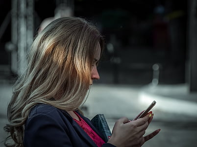 woman wearing black blazer holding smartphone thumbnail