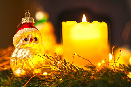 selective focus photo of owl wearing Santa hat ornament beside candle thumbnail