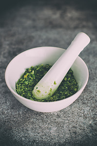 white ceramic bowl with pestle and green leaf spices thumbnail