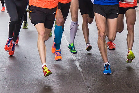 group of people wearing running shoes running on road thumbnail