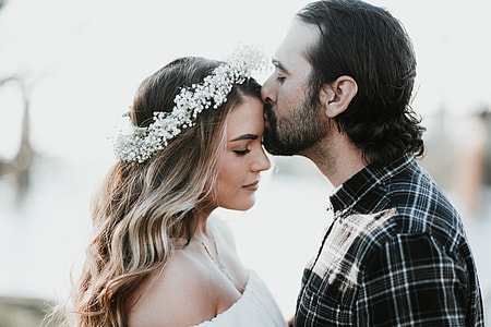 man wearing black, white and gray plaid print dress shirt kissing girl on forehead thumbnail