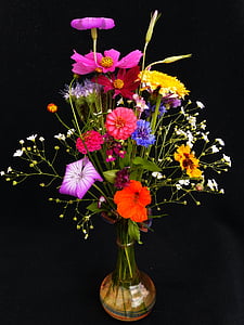 red-blue-and-yellow petaled flowers in amber glass vase thumbnail
