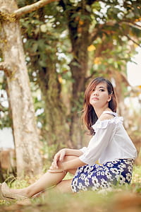 shallow focus photography of woman sitting on grass field thumbnail