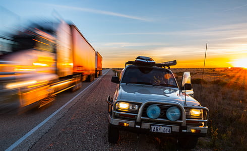 vehicle traveling on road during sunset thumbnail