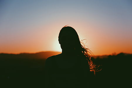 silhouette photography of woman looking on mountain during golden hour thumbnail
