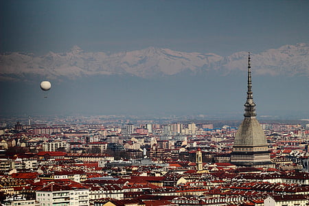 aerial photography of tower surrounded by buildings with hot air balloon on air thumbnail