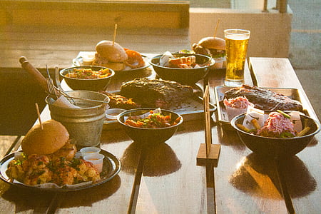 bun and meat patties on plate beside bucket on table thumbnail