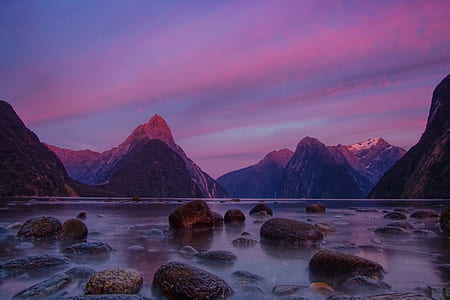 brown mountain surrounded with body of water thumbnail