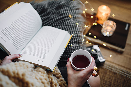 Woman drinking tea and reading book thumbnail