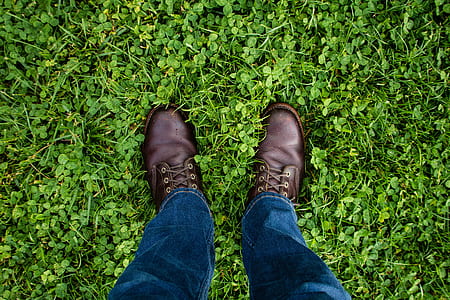 man wearing blue jeans and brown leather shoes standing on green field thumbnail