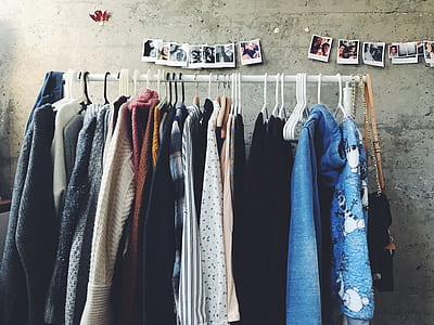 assorted shirts hangs on pole with photo above it thumbnail