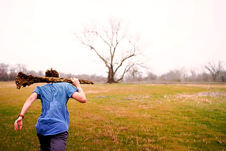 man holding trunk while running on green grass field thumbnail