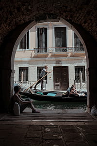 person paddling boat near house thumbnail