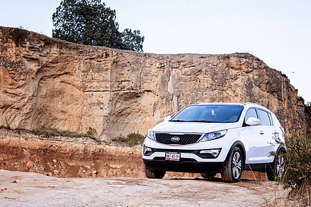 white Kia 5-door hatchback park near cliff during daytime thumbnail