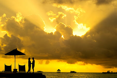 Silhouette Photo of Man and Woman Beside Body of Water during Sunset thumbnail