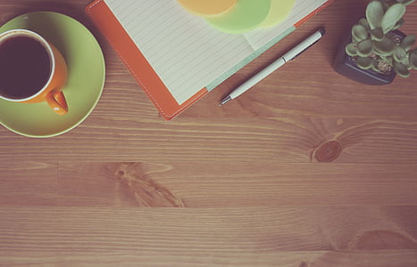 orange and white ceramic coffee mug on green ceramic saucer thumbnail