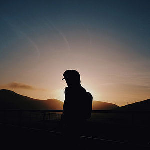 silhouette of man leaning on railings thumbnail