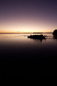 silhouette of boat on dock golden hour photography thumbnail