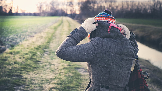 woman walking on green grass field at daytime thumbnail