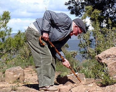 man holding cane near tree thumbnail