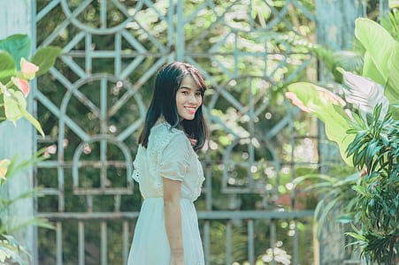 Woman In White Dress Looking Back While Smiling thumbnail