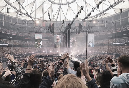crowd watching concert inside coliseum during daytime thumbnail