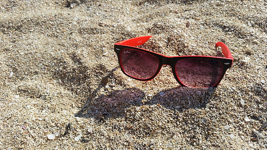 black and red framed wayfarer sunglasses on sand thumbnail