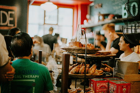 man sitting near baked bread inside room thumbnail