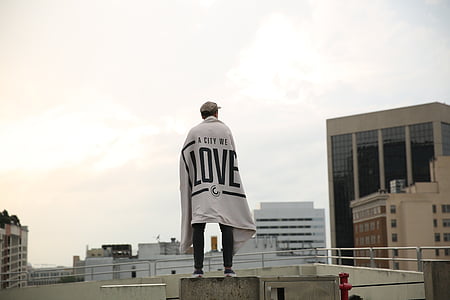 person standing on white building during daytime thumbnail