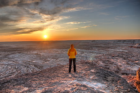person standing on mountain facing sun thumbnail